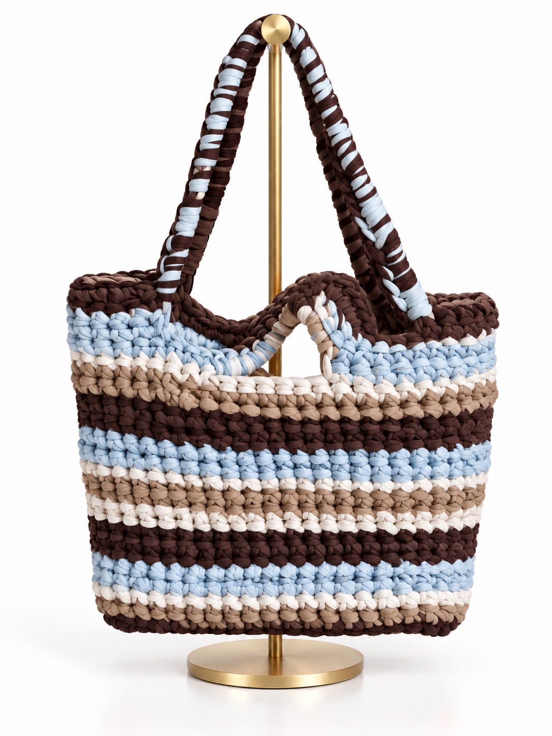 Bolsa tejida a mano en trapillo con rayas café, azul cielo, arena y crema, y asas tejidas café con azul
