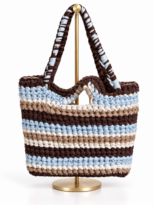 Bolsa tejida a mano en trapillo con rayas café, azul cielo, arena y crema, y asas tejidas café con azul